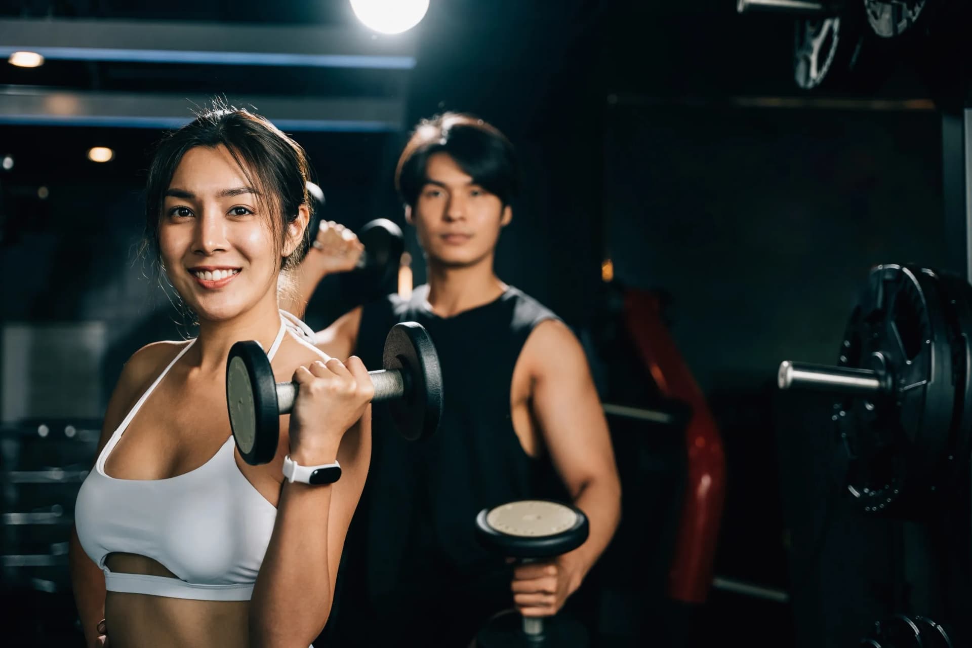 Two people training with dumbbells at a Chiang Mai gym